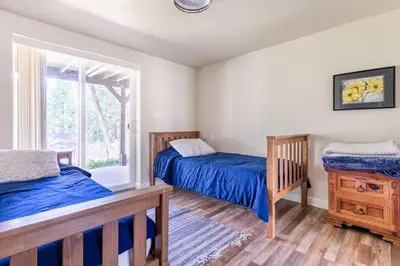 a bedroom with two beds and a window at Ponderosa Creekside Retreat in Mariposa