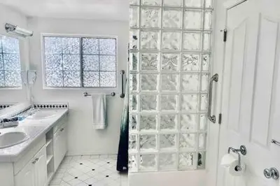 a white bathroom with a shower and a sink at Black Bear Haven Hot tub Pool table BBQ Darts in Oakhurst