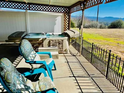 a porch with a hot tub and two chairs on a patio at Crane Suite Hot Tub Bbq King Bed- Sleeps 4 in Ahwahnee