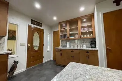 a kitchen with a cat sitting in front of a door at Creekside Dream Game Room Sleeps 12 bbq near town in Oakhurst
