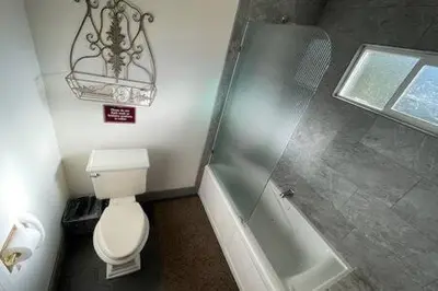 a bathroom with a toilet and a bath tub at Creekside Dream Game Room Sleeps 12 bbq near town in Oakhurst