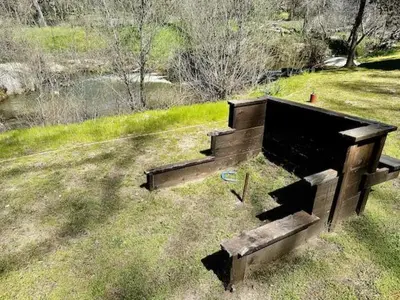 a wooden bench sitting in the middle of a field at Creekside Dream Game Room Sleeps 12 bbq near town in Oakhurst