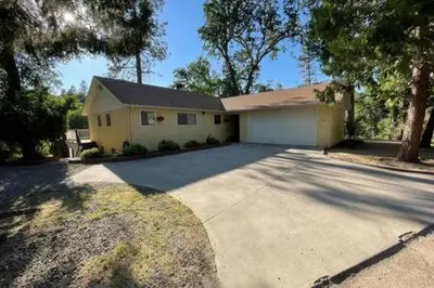 a large house with a driveway in front of it at Creekside Dream Game Room Sleeps 12 bbq near town in Oakhurst