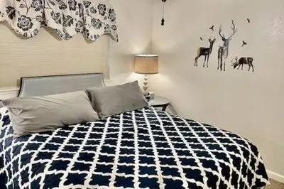 a bedroom with a bed with a black and white comforter at Deer Haven Hot Tub Foosball Pool Table in Ahwahnee