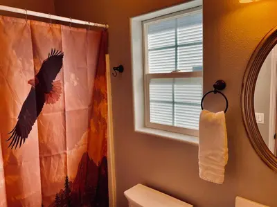 a bathroom with a shower curtain and a mirror at Eagle Nest River Views Hot Tub Games Sleeps 6 in Ahwahnee