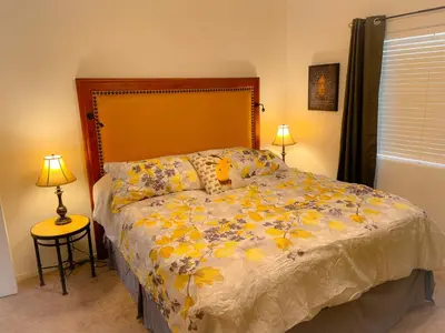 a bedroom with a large bed with yellow flowers at Honeybee Hive HOT TUB BBQ 8 minutes to Bass Lake Sleeps up to 6 in North Fork