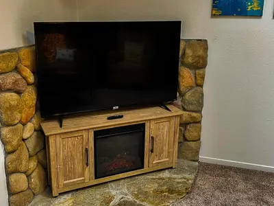 a television sitting on top of a stone wall at Honeybee Hive HOT TUB BBQ 8 minutes to Bass Lake Sleeps up to 6 in North Fork