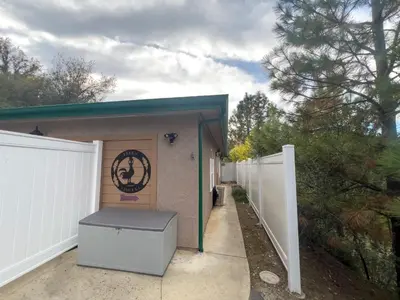 a small shed with a door and a fence at The Funky Chicken Hot Tub BBQ SLEEPS 4 in Ahwahnee
