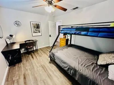 a bedroom with a bed and a desk and a ceiling fan at The Lighthouse Pet Friendly Hot Tub BBQ Sleeps 11 in Coarsegold