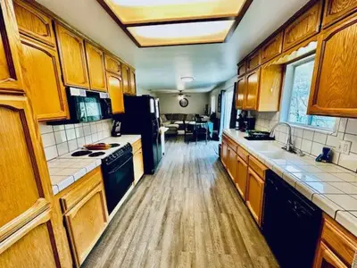 a large kitchen with wooden cabinets and appliances at The Lighthouse Pet Friendly Hot Tub BBQ Sleeps 11 in Coarsegold