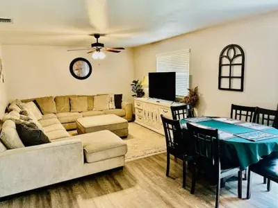 a living room with a couch and a table with chairs at The Lighthouse Pet Friendly Hot Tub BBQ Sleeps 11 in Coarsegold