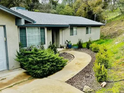 a house with a driveway in front of it at Lighthouse Suite Pet Friendly Hot Tub Sleeps 4 in Coarsegold