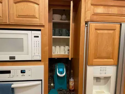 a kitchen with a cupboard with a microwave and appliances at Peacock Suite Hot Tub Sleeps up to 4 Bbq in Ahwahnee