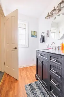 a kitchen with a sink and a black cabinet at Raccoon Hideout Hot Tub BBQ Arcade Darts in Oakhurst