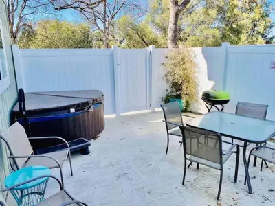 a patio with a table and chairs and a grill at Raccoon Hideout Hot Tub BBQ Arcade Darts in Oakhurst