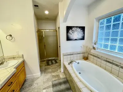 a bathroom with a tub and a sink and a window at White Feather Suite Hot Tub Private Sleeps 2 in Ahwahnee