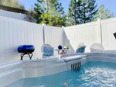 a backyard pool with a hot tub and chairs at White Feather Suite Hot Tub Private Sleeps 2 in Ahwahnee