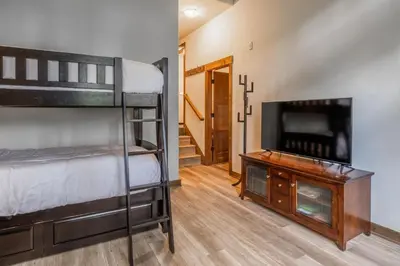 a bedroom with bunk beds and a flat screen tv at Woodwinds 32 in Mammoth Lakes