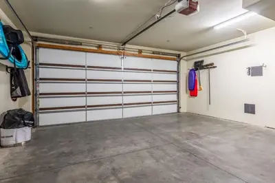 a garage with white garage doors and a concrete floor at Woodwinds 32 in Mammoth Lakes