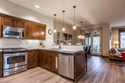 a kitchen with stainless steel appliances and wooden cabinets at Woodwinds 32 in Mammoth Lakes