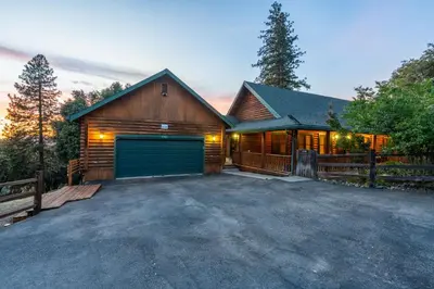a wooden house with a garage in the driveway at Yosemite Villa - log cabin with spectacular views & stargazing in Mariposa