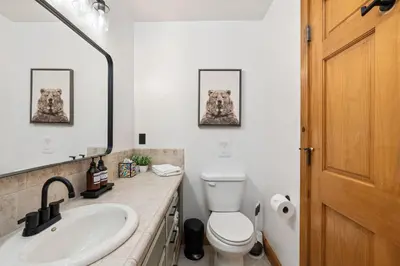 a bathroom with a toilet and a sink and a mirror at Yosemite Villa - log cabin with spectacular views & stargazing in Mariposa