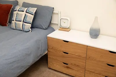 a bedroom with a bed and a dresser with a mirror at Modern 5 bed near hospitals and UC Merced in Merced