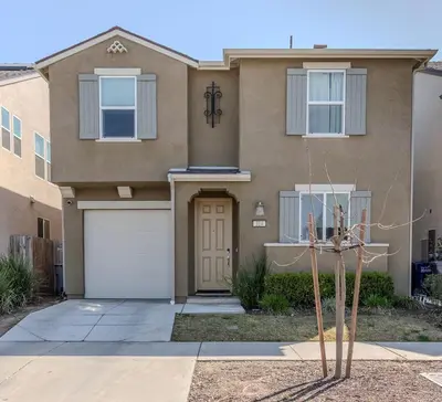 a house with a door and a garage at Modern 5 bed near hospitals and UC Merced in Merced