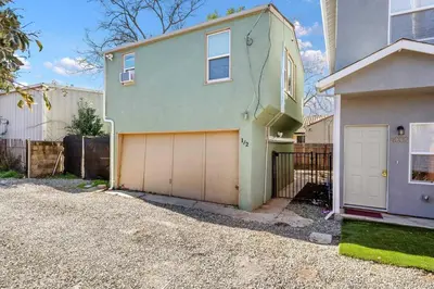 a green house with a garage and a fence at Cozy 1bdr/1br home near downtown in Sacramento
