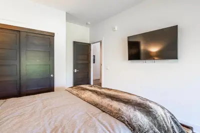 a bedroom with a bed with a television on the wall at Creekhouse 1583 in Mammoth Lakes