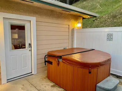 a wooden tub sitting outside of a house at Foxs Den Hot Tub Bbq Queen Bed Sleeps 2 in Ahwahnee
