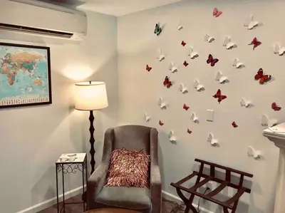 a room with a chair and butterflies on the wall at Butterfly Suite Hot Tub BBQ Private in Ahwahnee