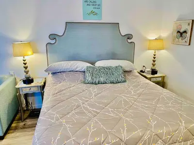 a bedroom with a large bed with two tables and two lamps at Butterfly Suite Hot Tub BBQ Private in Ahwahnee