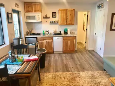 a kitchen with wooden cabinets and a table in a room at Butterfly Suite Hot Tub BBQ Private in Ahwahnee