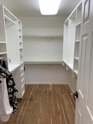 an empty closet with white shelves and a wooden floor at Executive home in a serene park like setting in Folsom