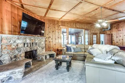 a living room with a couch and a stone fireplace at Spacious Coarsegold Getaway about 34 Mi to Yosemite! in Coarsegold