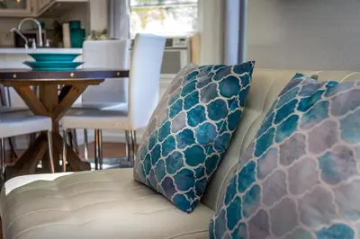 a couch with two pillows on it next to a table at **Kaweah River House** - 1/2 Mile to Sequoia Park in Three Rivers