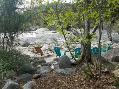 a group of chairs sitting next to a river at **Kaweah River House** - 1/2 Mile to Sequoia Park in Three Rivers