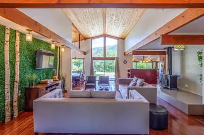 a living room with a couch and a tv at Sequoia River House, close to SNP, 2 Decks on Amazing River on 7acres in Three Rivers