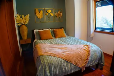 a bedroom with a bed and a window and a vase at Sequoia River House, close to SNP, 2 Decks on Amazing River on 7acres in Three Rivers