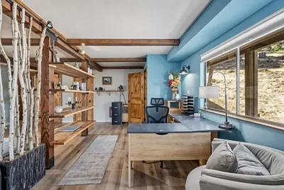 a home office with a blue wall and a desk at Water's Edge - Gorgeous Water Views! home in Groveland