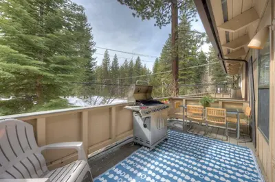 a screened in porch with a stove and chairs at Luxury Tahoe Getaway in Incline Village in Incline Village