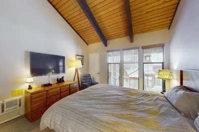 a bedroom with a large bed and a flat screen tv at St Moritz 55 F in Mammoth Lakes