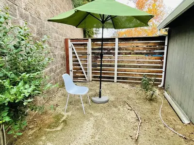 a green umbrella and a chair in a yard at Artist's retreat near the heart of the city in Sacramento