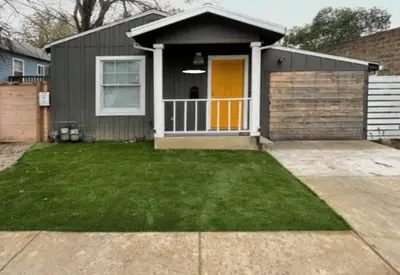 a house with a yellow door and a yard at Artist's retreat near the heart of the city in Sacramento