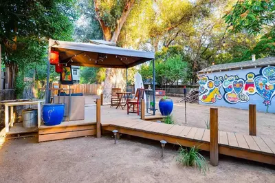 a wooden deck with a umbrella and a table and chairs at Smart Eclectic ART HOUSE near the beat in Sacramento