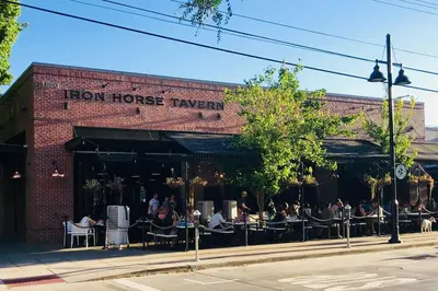 a brick building with people sitting at tables on a street at TINY ART HOUSE near the beat in Sacramento