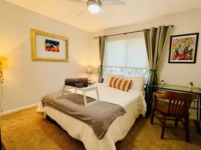 a bedroom with a bed and a chair and a desk at Artists Condo GAME ROOM Patio near UC Med Center in Sacramento