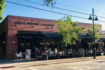 a brick building with people sitting at tables on a street at Artists Bungalow ARCADE King Beds near the beat in Sacramento