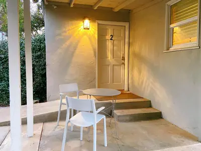 a table and two chairs on a porch with a door at Sweet Home in Sacramento Only 2mins to Freeway in Sacramento